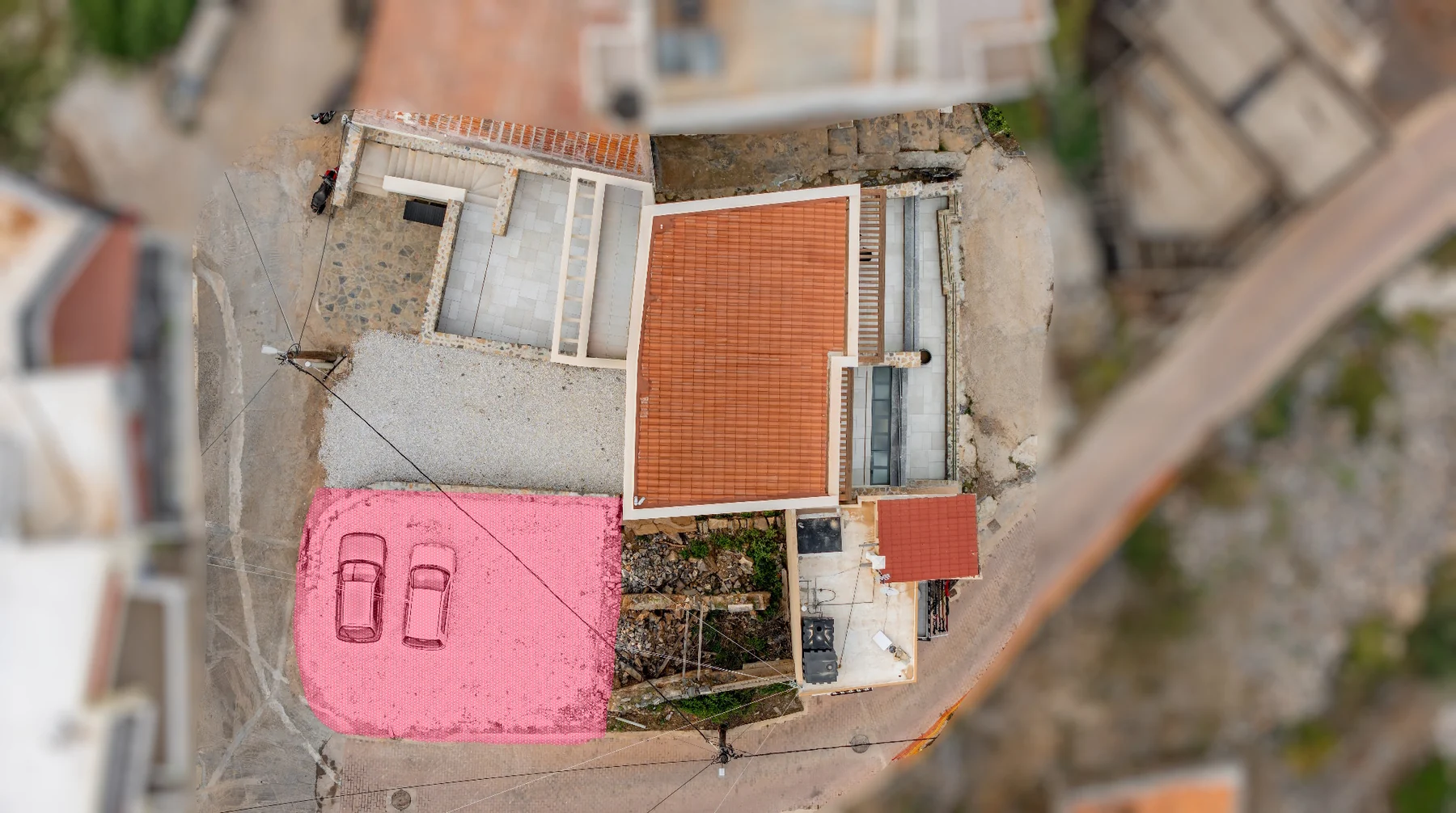Real top-down photograph of AEOS Elounda with the optional adjoining plot highlighted in pink